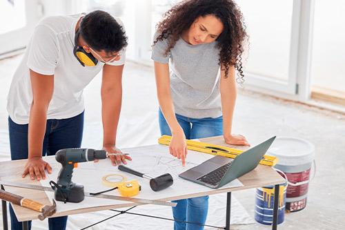 A man and woman are engaged in a project, working together in a comfortable home environment.