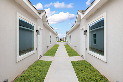 A spacious walkway connecting Tri-Plex, Four-Plex, and Six-Plex homes in Texas, designed for easy navigation and access.