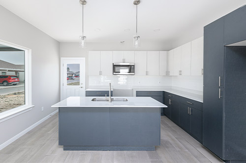 Interior view of a kitchen with a sink and refrigerator, showcasing a Tri-Plex, Four-Plex, or Six-Plex home in Texas.