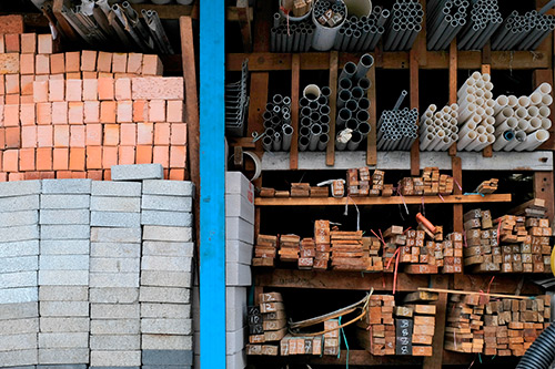 A man is positioned on a platform with bricks, focused on constructing a home during the winter season.
