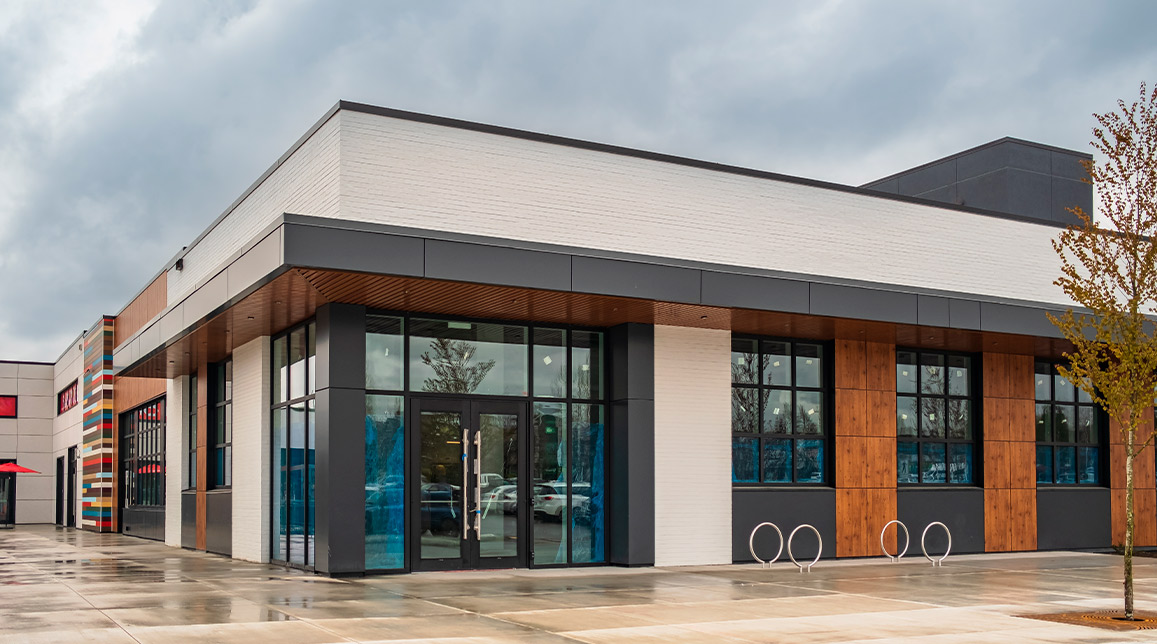 A modern building with a prominent glass entrance and a spacious parking area, representing commercial development in McAllen.