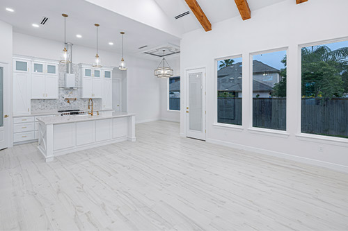A spacious kitchen featuring white cabinets and wooden beams, showcasing modern design trends for the RGV area