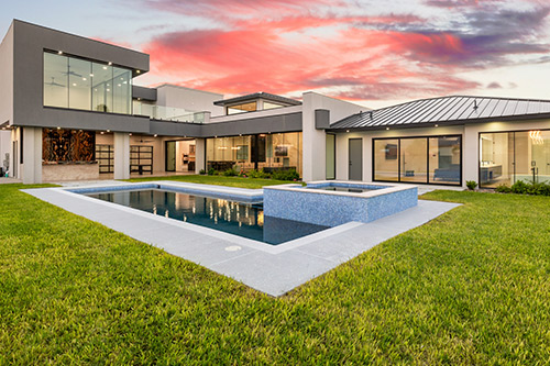 A large backyard pool surrounded by greenery, highlighting upcoming home design trends for the RGV area in 2026. Guzman Construction
