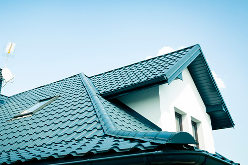 A house featuring a blue roof and a white chimney, built before the hurricane.