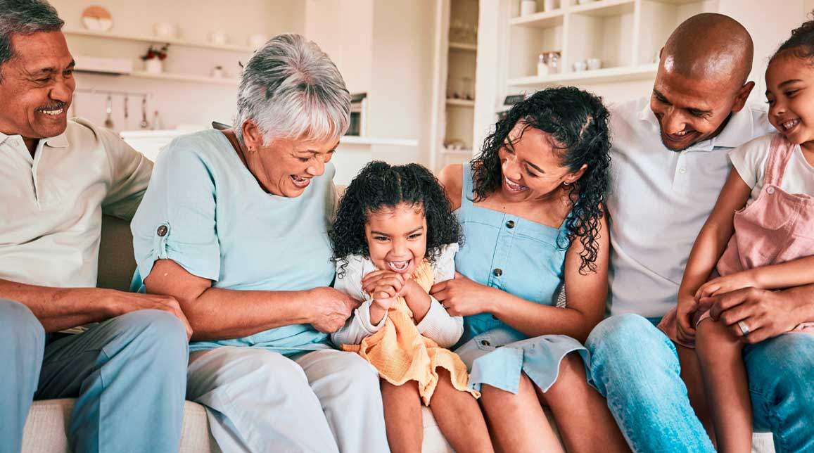 Family, tickle and child with happy people in relax home with love and bonding together on sofa. Happiness, grandparents and parents with kids, generations and relationship with laughter or fun game